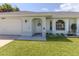House front view, featuring a white exterior, and a neatly landscaped lawn at 21019 Lawson Ave, Port Charlotte, FL 33952
