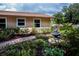 Landscaped yard featuring a brick pathway and a charming fountain nestled amongst the colorful flowers and greenery at 2521 Northway Dr, Venice, FL 34292