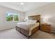 Bright bedroom features a large window, tray ceiling with ceiling fan, and traditional wood furniture at 12000 Tapestry Ln, Venice, FL 34293