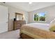 Serene bedroom with a comfortable bed, wooden dresser, and a bright window at 12000 Tapestry Ln, Venice, FL 34293