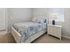 This bedroom has a beautiful blue flower quilt, next to a white dresser and lamp at 12000 Tapestry Ln, Venice, FL 34293