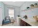 Bright laundry room with built-in shelving and comfortable seating area at 12232 Stuart Dr, Venice, FL 34293