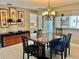 Bright dining room with a chandelier and view into kitchen at 473 Wexford Cir # 97, Venice, FL 34293