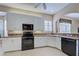 Modern kitchen with white cabinets, black appliances, and granite countertops at 1586 Monarch Dr # 1586, Venice, FL 34293