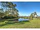 Peaceful waterfront view with lush landscaping and homes reflecting in the water at 1586 Monarch Dr # 1586, Venice, FL 34293