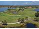 Aerial view of a golf course with water features and players on the course at 277 Mestre Pl, North Venice, FL 34275