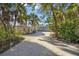 A gravel driveway winds through lush landscaping toward a home at 5 N Casey Key Rd, Osprey, FL 34229