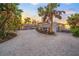 Landscaped grounds with palm trees and a beach house at sunset at 5 N Casey Key Rd, Osprey, FL 34229