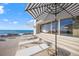 Beachfront patio with lounge chairs and striped umbrella at 5 N Casey Key Rd, Osprey, FL 34229