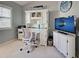 Bright home office features built-in desk, comfortable chair, and large TV at 1342 Capri Isles Blvd # 14, Venice, FL 34292