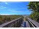 Wooden boardwalk leads to a sandy beach under a clear sky at 708 Tamiami S Trl # 308, Venice, FL 34285