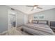 Bedroom with view into bathroom, ceiling fan and coastal decor at 708 Tamiami S Trl # 308, Venice, FL 34285