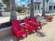 Relaxing community space with red Adirondack chairs and a white bench at 13587 Vancanza Dr, Venice, FL 34293