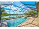 Beautiful screened-in pool area with a relaxing lounge and dining area, overlooking a serene lake at 13587 Vancanza Dr, Venice, FL 34293