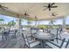 Covered outdoor seating area with tables, chairs, and ceiling fans at 19256 Lappacio St, Venice, FL 34293