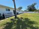 The backyard features a white fence, well manicured lawn and landscaping around the rear elevation at 514 Palm Ave, Nokomis, FL 34275