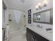 Modern bathroom featuring a single sink vanity, mosaic mirror, shower-tub combo, and updated lighting at 514 Palm Ave, Nokomis, FL 34275