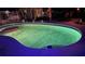 A freeform outdoor pool at night glows with the reflection of the trees and a rubber floatie at 514 Palm Ave, Nokomis, FL 34275