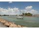 Sailboat sailing into inlet, framed by rocky shoreline under a sunny, cloudy sky at 514 Palm Ave, Nokomis, FL 34275