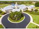 Aerial view of Pelican Pointe clubhouse, featuring circular driveway and lush landscaping at 1078 Tuscany Blvd, Venice, FL 34292