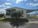 Charming home with a screened-in porch, carport, and a well-maintained front lawn on a sunny day at 428 Boxwood Dr, Venice, FL 34285