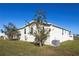 Exterior rear view of home with green grass and a view of nearby homes at 428 Boxwood Dr, Venice, FL 34285