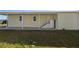 Home exterior featuring covered outdoor patio and stairs to elevated door entrance at 428 Boxwood Dr, Venice, FL 34285