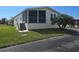 Charming home with a screened-in porch, carport, and a well-maintained front lawn on a sunny day at 428 Boxwood Dr, Venice, FL 34285