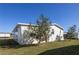 Rear exterior view of home showing neutral siding and small tree in the well-manicured yard at 428 Boxwood Dr, Venice, FL 34285