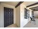 Welcoming condo entrance with decorative door, exterior display case, and cozy seating area at 766 Avenida Estancia # 196, Venice, FL 34292