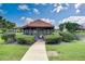 Exterior view of the screened-in gazebo with seating area, surrounded by landscaped bushes and fountain at 766 Avenida Estancia # 196, Venice, FL 34292