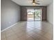 Bright living room offering sliding glass doors to a balcony, neutral paint, and tile flooring throughout at 766 Avenida Estancia # 196, Venice, FL 34292