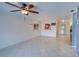 Open-concept living room with tile floors, a ceiling fan, and a pass-through to the modern kitchen at 766 Avenida Estancia # 196, Venice, FL 34292
