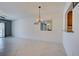 Bright living room featuring tile floors, a modern chandelier, and a convenient pass-through to the kitchen at 766 Avenida Estancia # 196, Venice, FL 34292