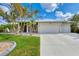 Well-maintained house featuring a two-car garage and lush landscaping at 1219 Nantucket Rd, Venice, FL 34293