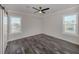 Spacious bedroom with dark wood-look floors and ceiling fan at 127 Nautical Dr, North Port, FL 34287