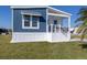 Side view of a single wide home with blue and white siding, and a covered porch at 127 Nautical Dr, North Port, FL 34287