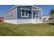 Rear view of a single wide home with blue and white siding, and a covered porch at 127 Nautical Dr, North Port, FL 34287