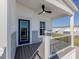 Covered porch with ceiling fan, blue door, gray stone, and composite decking at 127 Nautical Dr, North Port, FL 34287