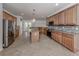 Modern kitchen with granite countertops, wood cabinetry, and stainless steel appliances at 13240 Amerigo Ln, Venice, FL 34293