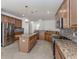 Modern kitchen with granite countertops, wood cabinetry, and stainless steel appliances at 13240 Amerigo Ln, Venice, FL 34293