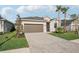 Inviting home with a paved driveway, two-car garage, and lush green lawn at 19045 Moscato Ct, Venice, FL 34293