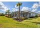 Home with grassy backyard and screened lanai at 25544 Royal Tern Ln, Englewood, FL 34223