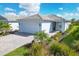 Single-story home with a white garage door and landscaping at 25544 Royal Tern Ln, Englewood, FL 34223