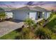 Single-story home with a white garage door and landscaping at 25544 Royal Tern Ln, Englewood, FL 34223