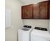 Laundry room with washer, dryer, and upper cabinets at 25544 Royal Tern Ln, Englewood, FL 34223