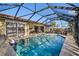 Screened pool and patio area with comfortable seating and sun umbrella at 1701 Boca Raton Ct, Punta Gorda, FL 33950