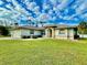 Single-story home with attached garage and manicured lawn at 18194 Driggers Ave, Port Charlotte, FL 33948