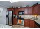 Kitchen with wood cabinets, granite counters, and stainless appliances at 250 Santa Maria St # 118, Venice, FL 34285