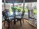 Bright sunroom with glass windows, wicker furniture, and rocking chair at 5581 Linksman Pl, North Port, FL 34287